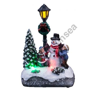 Lighted Up  Christmas Scene With Children Decorate The Snowman